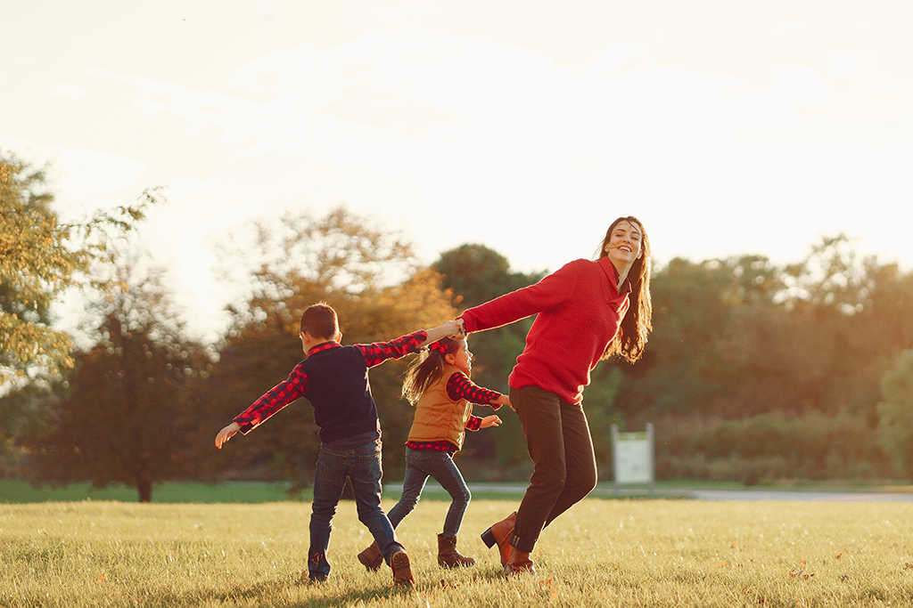  A mother playing joyfully with her children outdoors